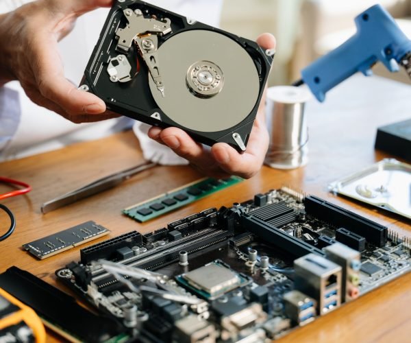 Technician repairing inside of hard disk drive by screwdriver. the concept of data, hardware, technician and technology. computer hardware, repairing, upgrade